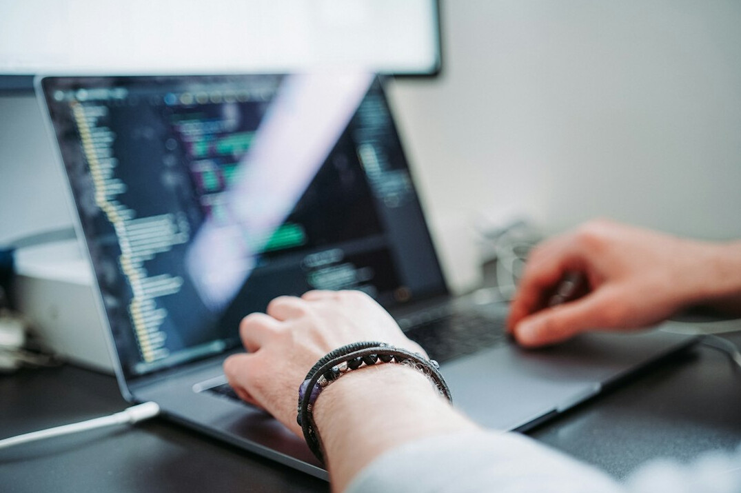 developer writing code on laptop